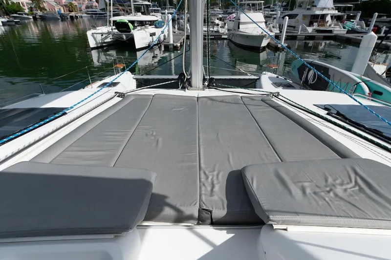 Miss Summer Yacht Photos Pics 2014 Lagoon 450 catamaran with gray deck cushions, docked in a marina.