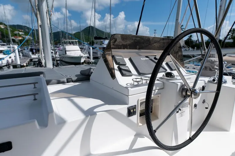 Miss Summer Yacht Photos Pics Steering wheel of a 2014 Lagoon 450 catamaran docked at a marina.