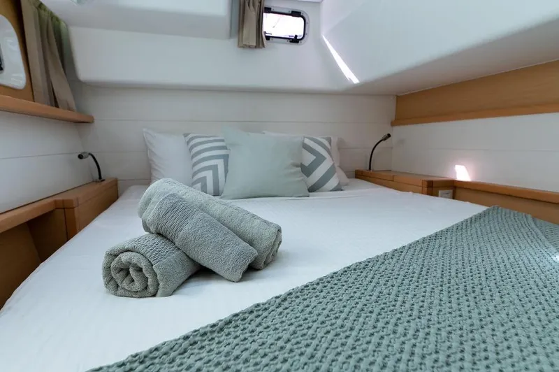 Miss Summer Yacht Photos Pics Cozy cabin interior of 2014 Lagoon 450 catamaran with neatly arranged bed and towels.
