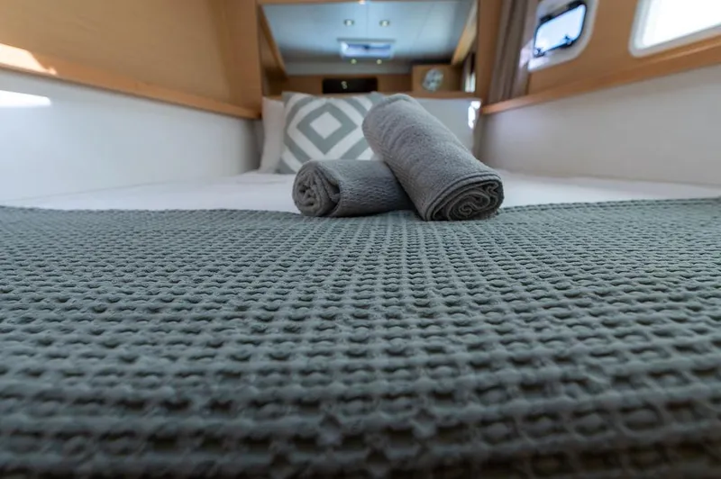 Miss Summer Yacht Photos Pics Cozy cabin interior of 2014 Lagoon 450 catamaran with neatly arranged towels and bedding.