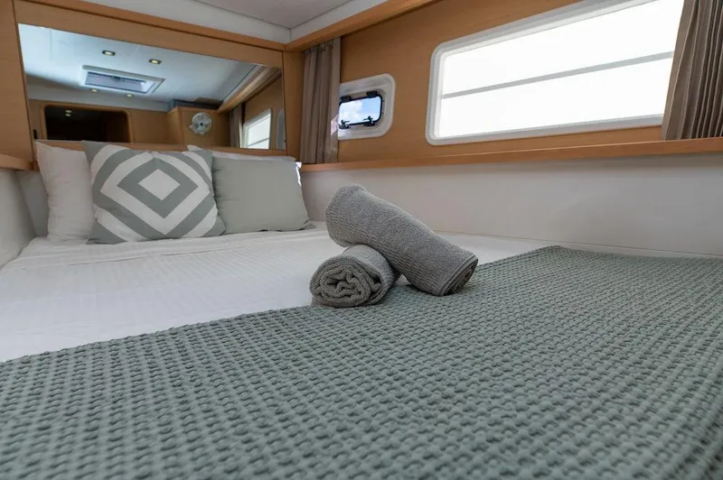 Miss Summer Yacht Photos Pics Luxurious cabin interior of 2014 Lagoon 450 yacht with neatly arranged bed and towels.