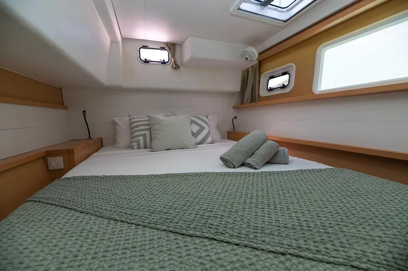 Miss Summer Yacht Photos Pics Cozy cabin interior of 2014 Lagoon 450 yacht with neatly arranged bed and porthole windows.