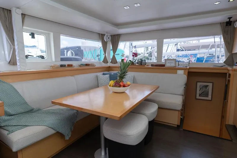 Miss Summer Yacht Photos Pics Interior of 2014 Lagoon 450 catamaran with cozy dining area and fruit bowl centerpiece.
