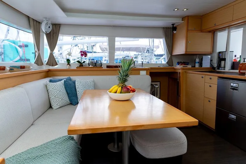 Miss Summer Yacht Photos Pics Interior of 2014 Lagoon 450 yacht with cozy dining area and fruit centerpiece.