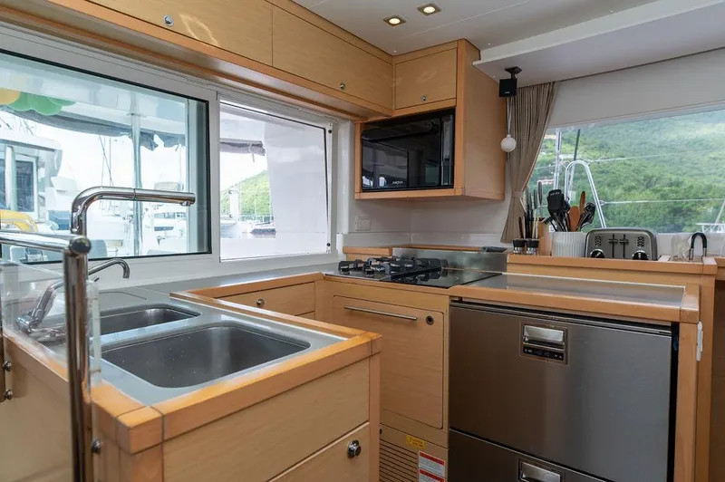 Miss Summer Yacht Photos Pics Modern kitchen interior on 2014 Lagoon 450 yacht with stainless steel appliances and wooden cabinetry.