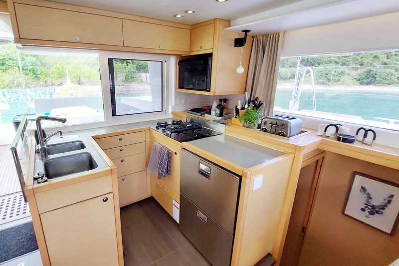 Miss Summer Yacht Photos Pics Modern kitchen interior of 2014 Lagoon 450 catamaran with appliances and scenic window view.