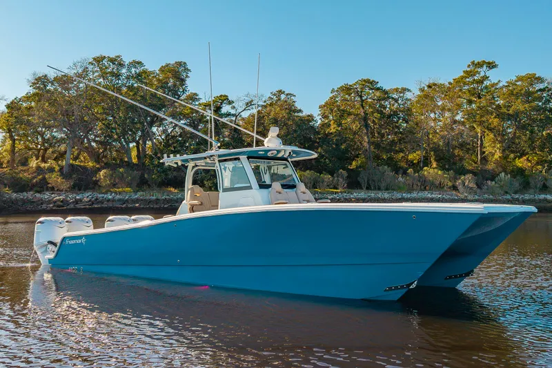 Krusty Krab II Yacht Photos Pics Freeman 38 catamaran 2025 on calm water with trees in background.