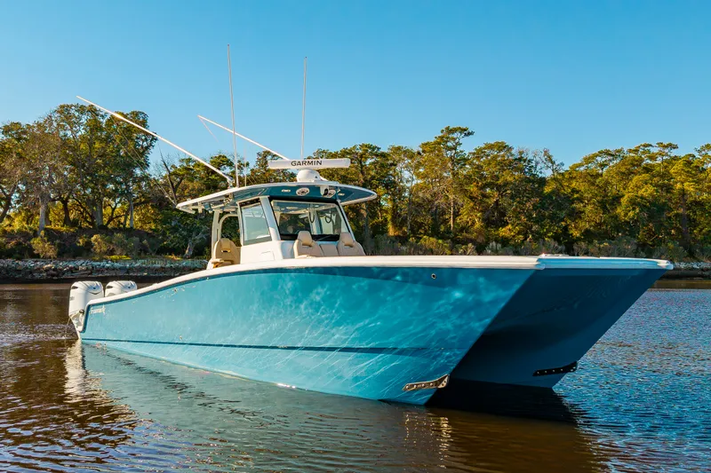 Krusty Krab II Yacht Photos Pics Freeman 38 boat 2025 on calm water with wooded backdrop.