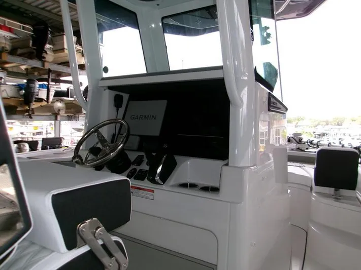  Yacht Photos Pics 2026 Blackfin 242 HB boat cockpit with Garmin navigation system and steering wheel.