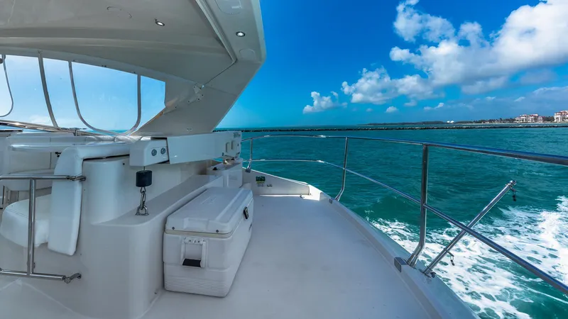 Next To Sell Yacht Photos Pics Luxurious 2005 Marquis 59 yacht cruising on clear blue waters under a sunny sky.