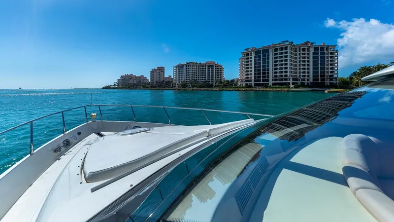 Next To Sell Yacht Photos Pics Luxury Marquis 59 yacht cruising near waterfront buildings, clear blue sky and sea, 2005 model.