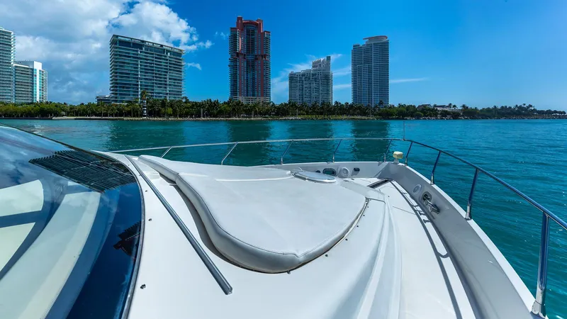 Next To Sell Yacht Photos Pics 2005 Marquis 59 yacht cruising near modern city skyline and blue waters.