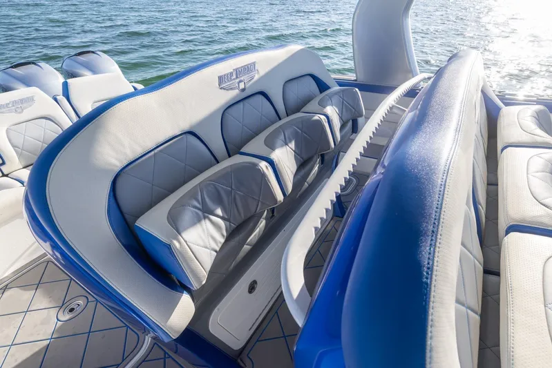Loan Shark II Yacht Photos Pics 2019 Deep Impact 399 Sport boat interior with blue and white seating, on water.