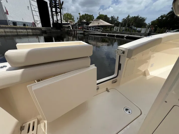  Yacht Photos Pics 2026 Scout 260 LXF boat interior with seating, docked by calm water.