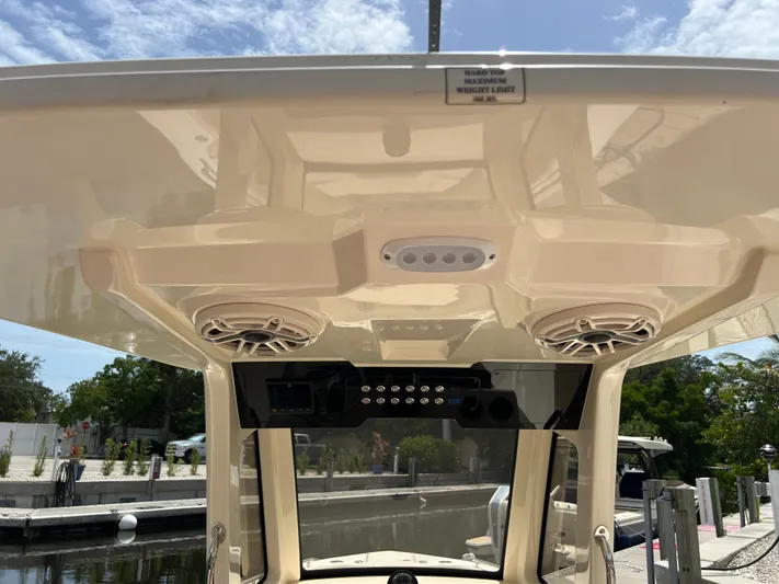 Yacht Photos Pics 2026 Scout 260 LXF boat hardtop with speakers and control panel, docked under clear sky.