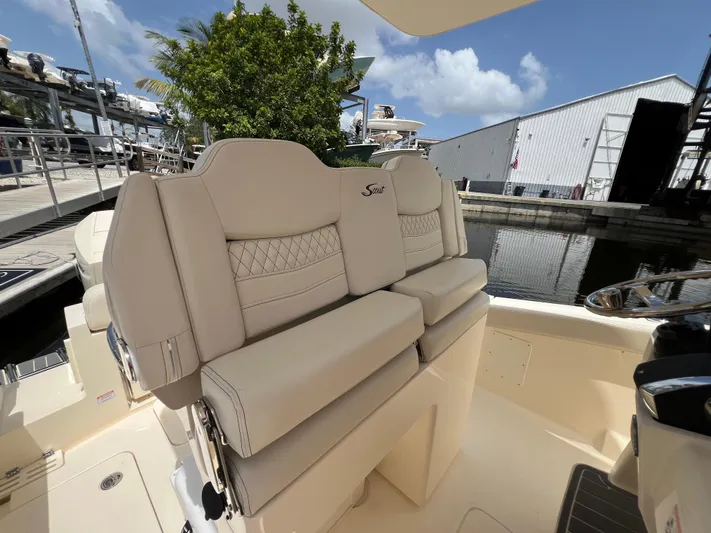  Yacht Photos Pics 2026 Scout 260 LXF boat interior with beige seating at a marina.
