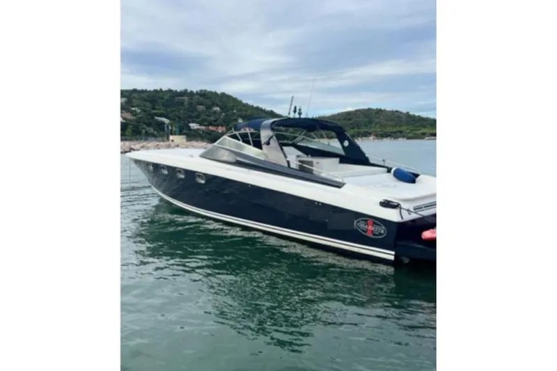  Yacht Photos Pics 1998 Otam Cigarette Heritage 45 boat on calm water, scenic background.