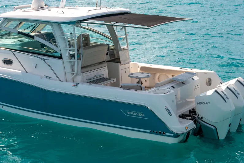 Yacht Photos Pics 2021 Boston Whaler 345 Conquest boat on turquoise water, featuring twin Mercury engines.