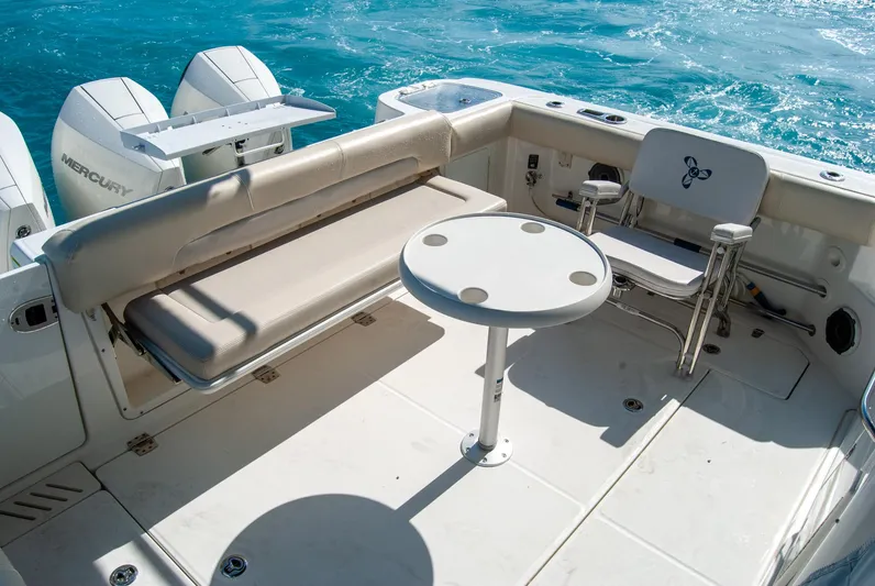  Yacht Photos Pics Boston Whaler 345 Conquest 2021 boat deck with seating and table, ocean backdrop.