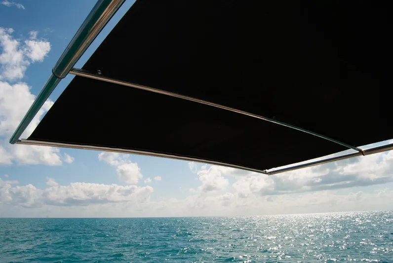 Yacht Photos Pics Boston Whaler 345 Conquest 2021 boat canopy over ocean with blue sky and clouds.