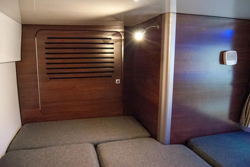  Yacht Photos Pics 2021 Boston Whaler 345 Conquest cabin interior with wooden paneling and cushioned seating.