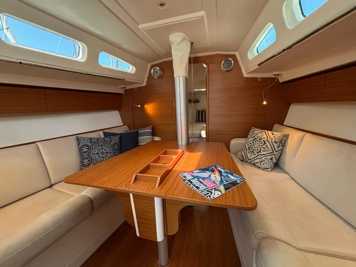 Rambunxious Yacht Photos Pics Luxurious interior of 2014 X-Yachts Xp 38 sailboat with elegant seating and wooden table.