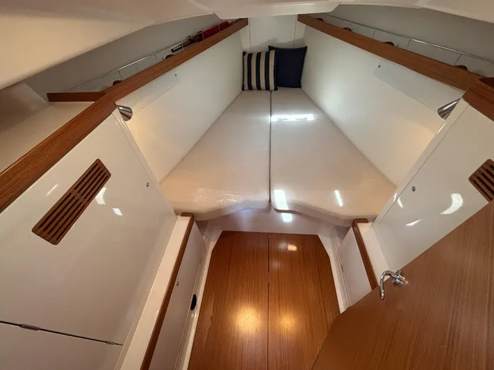 Rambunxious Yacht Photos Pics Interior cabin of 2014 X-Yachts Xp 38, featuring cozy bedding and wooden accents.