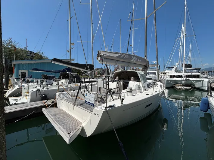 Rambunxious Yacht Photos Pics 2014 X-Yachts Xp 38 sailboat docked, for sale, in a marina under clear blue skies.