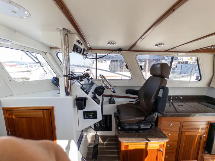  Yacht Photos Pics Interior of a 2021 Ocean Sport 26/27 boat, featuring helm and seating area.
