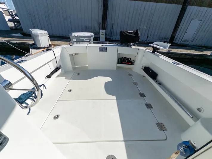  Yacht Photos Pics 2021 Ocean Sport 26/27 boat deck with storage compartments and steering wheel.