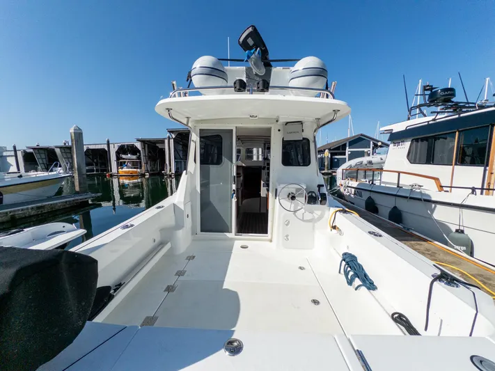  Yacht Photos Pics 2021 Ocean Sport 26/27 boat docked at marina, showcasing spacious deck and clear blue sky.
