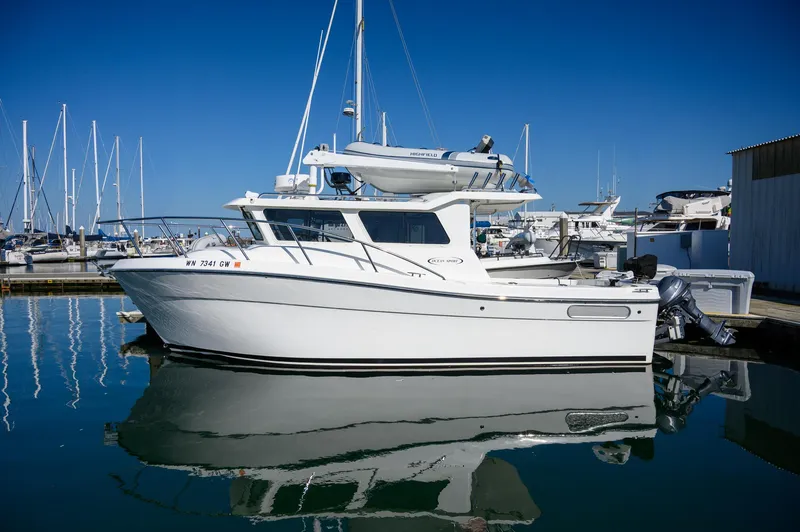  Yacht Photos Pics 2021 Ocean Sport 26/27 boat docked in marina, clear blue sky, calm water reflection.