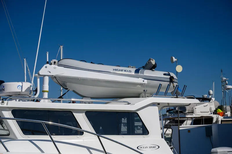  Yacht Photos Pics 2021 Ocean Sport 26/27 boat with a Highfield dinghy on top, docked under clear blue sky.