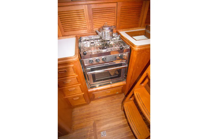 Sea G Yacht Photos Pics Galley kitchen in 1983 Cape George Cutter with wooden cabinetry and stove.