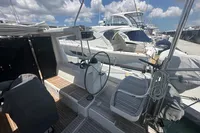 Sailboat cockpit of 2011 Moody DS 45 with steering wheel, docked at marina under blue sky.