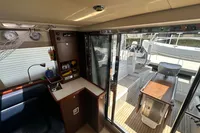 Interior view of a 2011 Moody DS 45 yacht, featuring a cozy seating area and sliding glass doors.