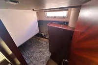 Cozy cabin interior of 2011 Moody DS 45 sailboat with bed and wooden furnishings.