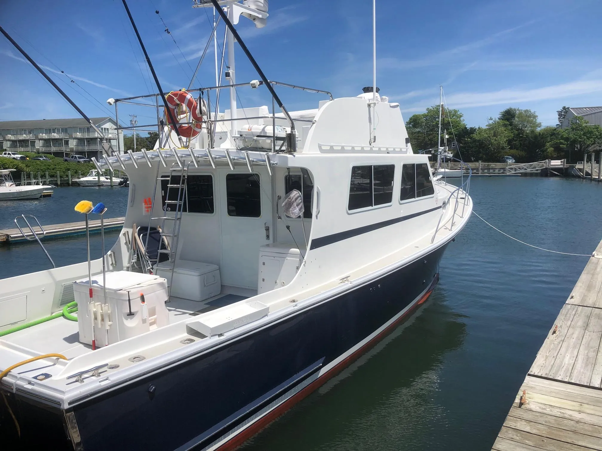 2003 Wesmac Flybridge boat docked in a marina under clear blue skies.