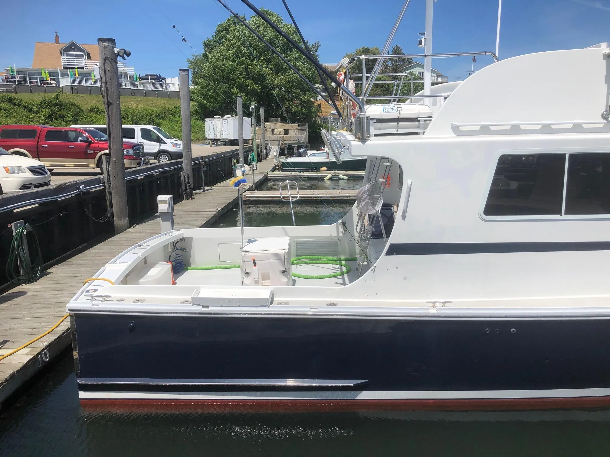 2003 Wesmac Flybridge boat docked at marina under clear blue sky.