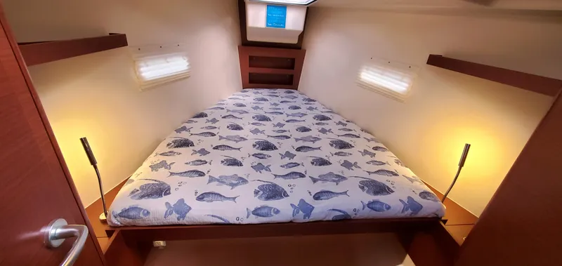 Hanse 388 #396 Yacht Photos Pics 2024 Hanse 388 yacht cabin with fish-patterned bedding and warm lighting.