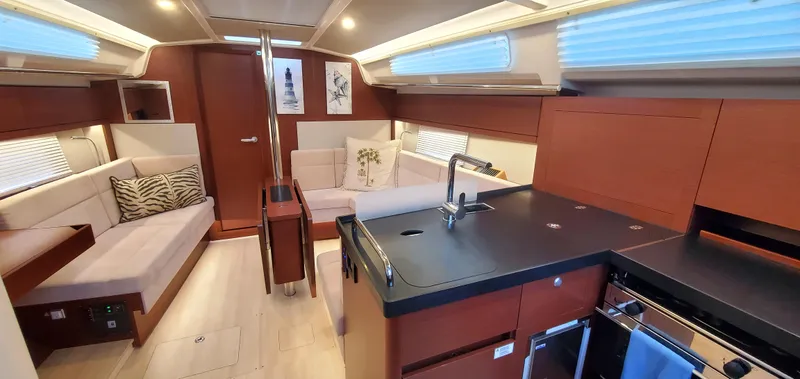 Hanse 388 #396 Yacht Photos Pics Luxurious interior of 2024 Hanse 388 yacht with modern kitchen and cozy seating area.