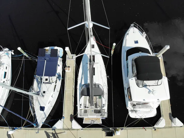 Hanse 388 #396 Yacht Photos Pics Aerial view of 2024 Hanse 388 sailboat docked between two other boats.
