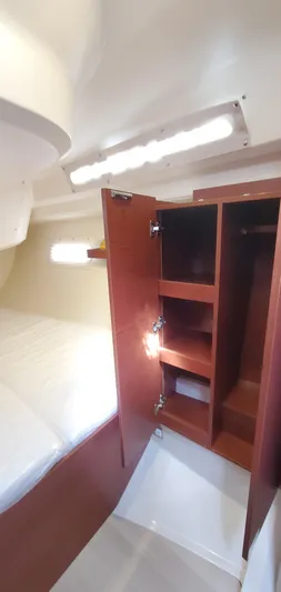 Hanse 388 #396 Yacht Photos Pics 2024 Hanse 388 yacht interior with open wooden cabinet and bed.