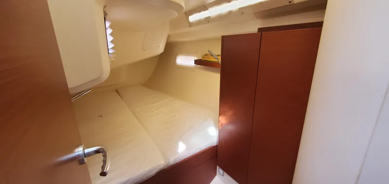 Hanse 388 #396 Yacht Photos Pics 2024 Hanse 388 yacht cabin interior with wooden finishes and cozy bed.