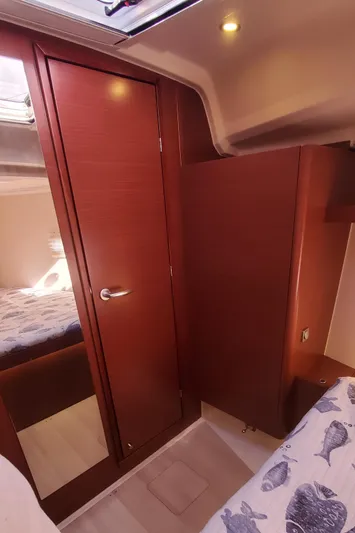 Hanse 388 #396 Yacht Photos Pics 2024 Hanse 388 yacht interior with wooden cabinetry and cozy bedding.