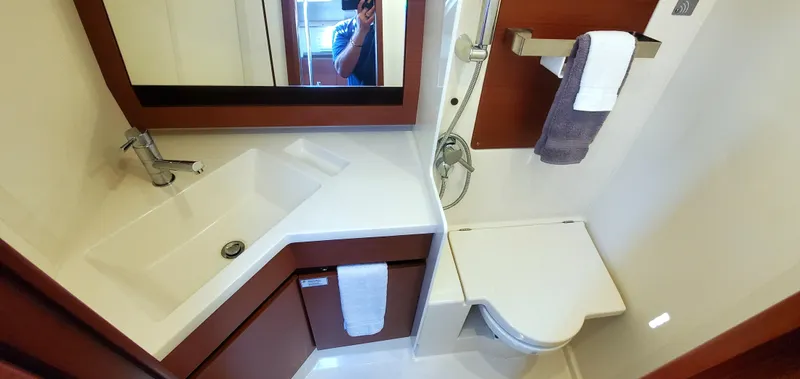 Hanse 388 #396 Yacht Photos Pics 2024 Hanse 388 yacht bathroom with modern sink, toilet, and mirror.