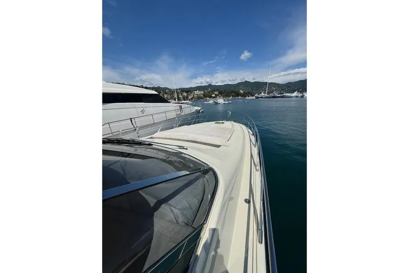  Yacht Photos Pics 2002 Riva 59 Mercurius yacht docked in a scenic marina under a clear blue sky.