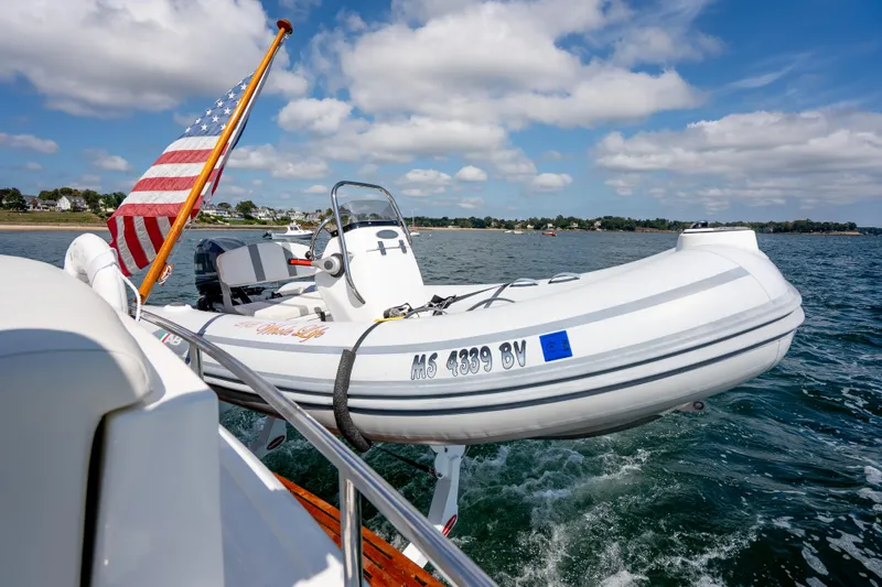 Whole Life Yacht Photos Pics 2011 Grand Banks 46 Eastbay SX with dinghy and American flag on open water.