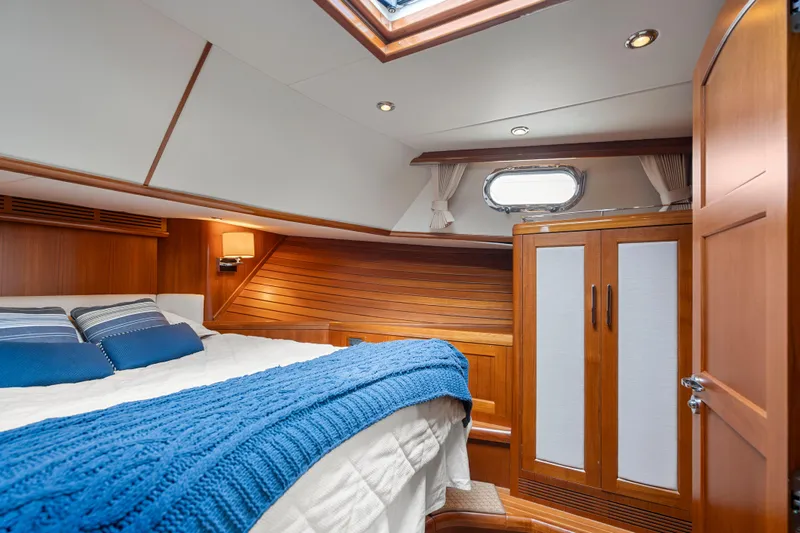Whole Life Yacht Photos Pics Luxurious cabin interior of 2011 Grand Banks 46 Eastbay SX yacht with wood paneling and cozy bedding.