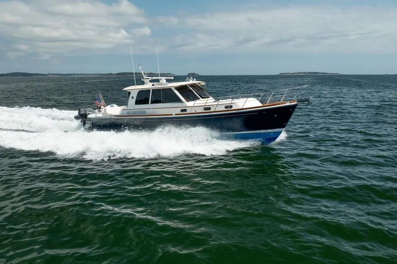 Whole Life Yacht Photos Pics 2011 Grand Banks 46 Eastbay SX cruising on open water under a partly cloudy sky.
